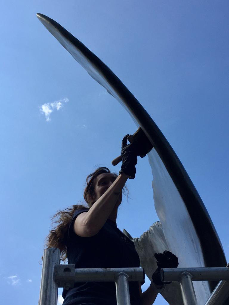 Lucy Branch conducting conservation treatment on Richard Farrington’s Whale’s Tail, Gunwharf Quays Sculpture conservator Lucy Branch performing bronze maintenance work on Richard Farrington's Whale's Tail in Gunwharf Quays, Portsmouth
